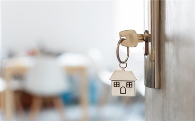 Photograph of a house shaped keyring in a door